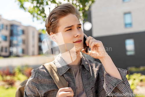 Image of teenage student boy calling on smartphone in city