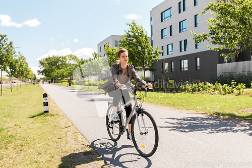 Image of young man riding bicycle on city street