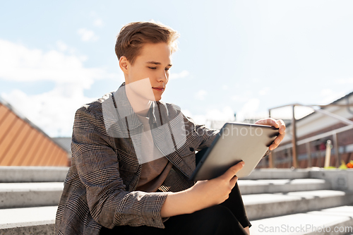 Image of young manor teenage boy with tablet pc in city