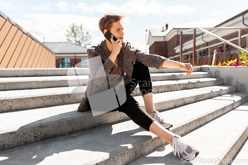 Image of teenage boy calling on smartphone in city