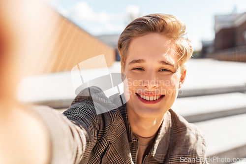 Image of young man or teenage boy taking selfie in city