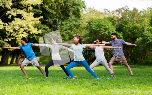 Image of group of people doing yoga at summer park
