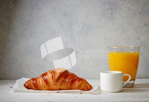 Image of freshly baked croissant, espresso and juice