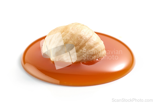 Image of hazelnut in melted caramel drop
