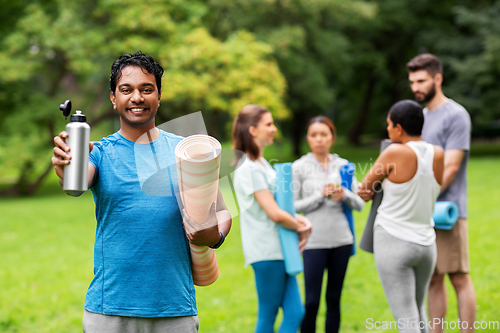 Image of happy man with bottle over people meeting for yoga
