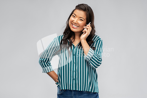 Image of happy asian young woman calling on smartphone
