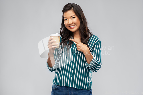 Image of happy asian woman showing takeaway coffee cup