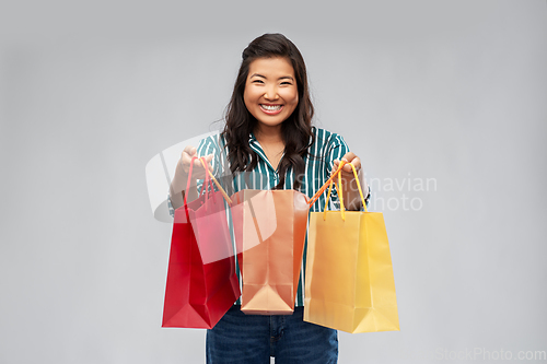 Image of happy asian woman with shopping bags