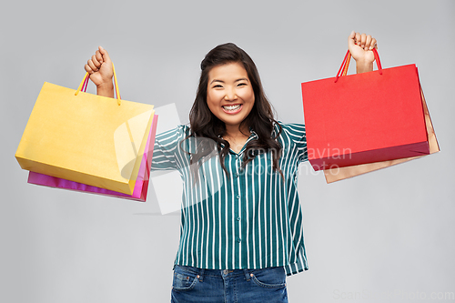 Image of happy asian woman with shopping bags