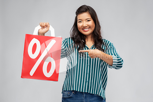 Image of asian woman with percentage sign on shopping bags