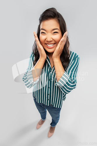 Image of happy asian woman over grey background