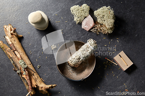 Image of white sage in cup and staff for magic ritual