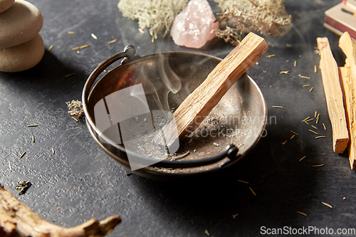 Image of palo santo stick in cup and staff for magic ritual