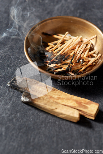 Image of palo santo sticks and cup with burnt matches