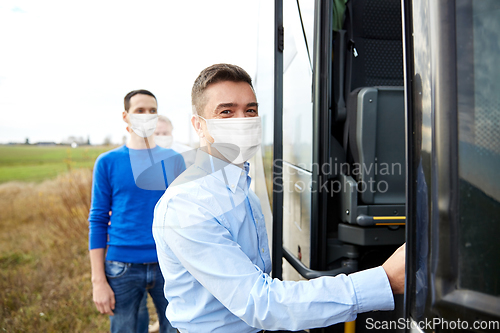 Image of group of passengers in masks boarding travel bus