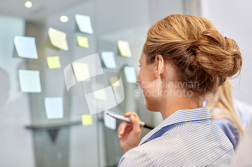 Image of business team with sticky notes on glass at office