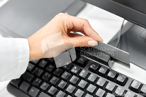 Image of close up of pharmacist's hand swiping credit card