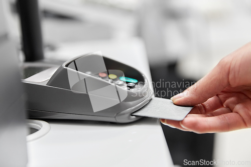 Image of close up of hand with credit card in card-reader