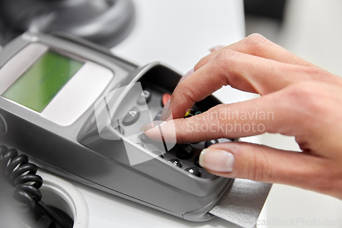 Image of close up of hand with credit card in card-reader