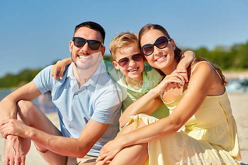 Image of happy family hugging on summer beach