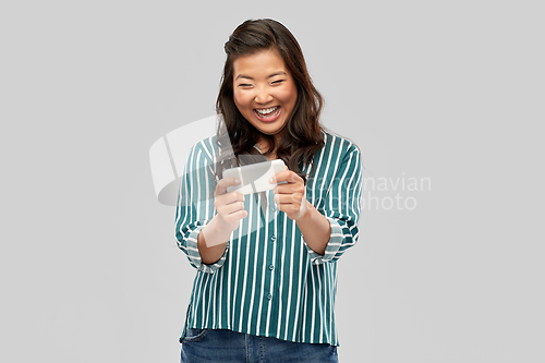 Image of happy asian woman using smartphone