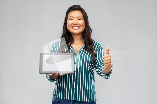 Image of happy asian woman with tablet pc showing thumbs up
