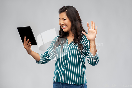 Image of happy asian woman having video call on tablet pc