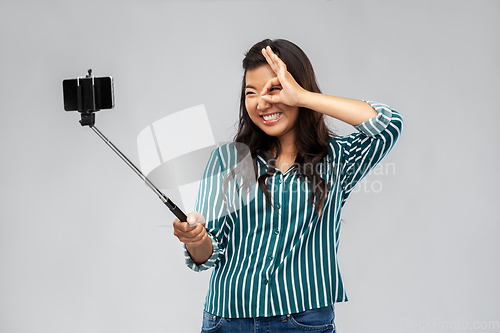 Image of happy asian woman taking selfie with smartphone