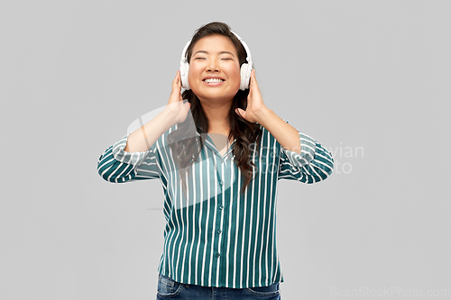 Image of asian woman in headphones listening to music