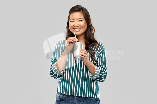 Image of happy smiling asian woman with can drink