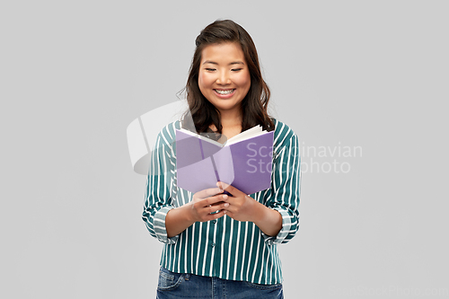 Image of happy asian woman reading book