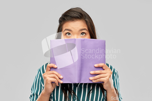 Image of asian woman hiding behind