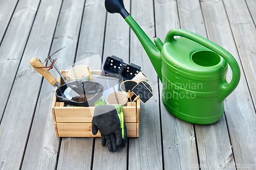 Image of box with garden tools and watering can in summer