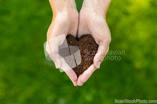 Image of cupped hands holding soil in shape of heart