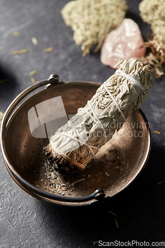 Image of white sage in cup and staff for magic ritual