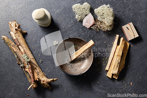 Image of palo santo stick in cup and staff for magic ritual