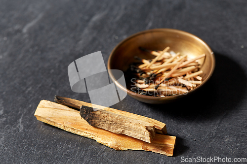 Image of palo santo sticks and cup with burnt matches