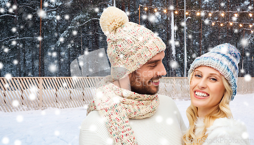 Image of happy couple over ice skating rink in winter