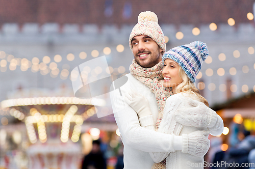 Image of couple in winter hugging over christmas market