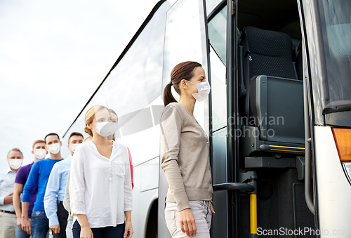 Image of group of passengers in masks boarding travel bus