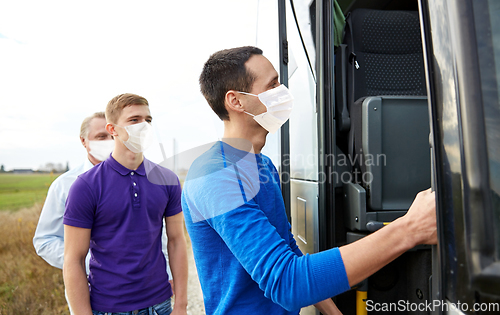 Image of group of passengers in masks boarding travel bus