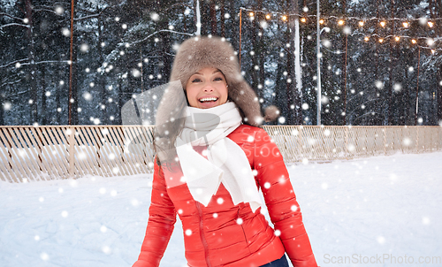 Image of happy woman in winter hat over ice skating rink