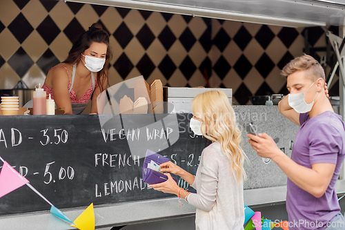 Image of seller and customers in masks at food truck