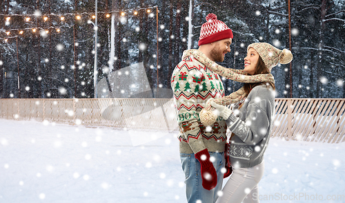 Image of couple in ugly sweaters on christmas ice rink