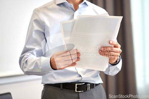 Image of close up of businessman with papers at office