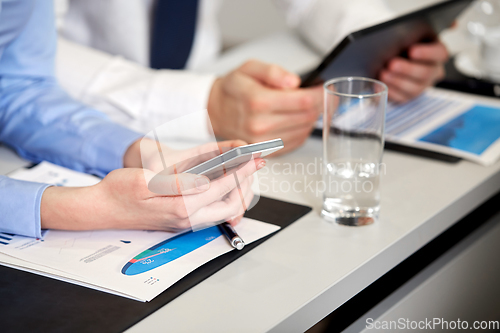 Image of close up of hands with smartphone at office