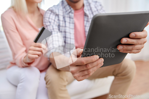 Image of couple with tablet pc and credit card at home