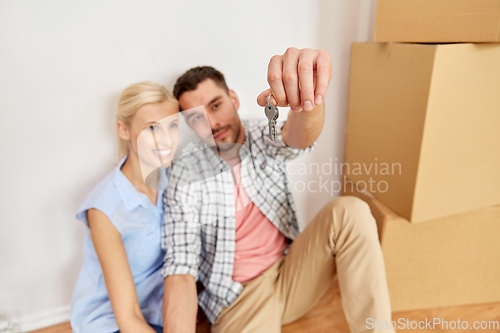 Image of happy couple with key and boxes moving to new home