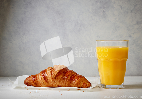 Image of freshly baked croissant and juice