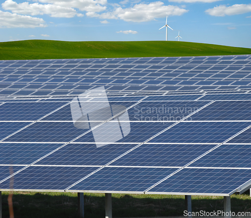 Image of Rows of solar panels, wind turbine and green nature